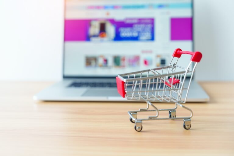 Shopping cart and laptop computer with marketplace website.