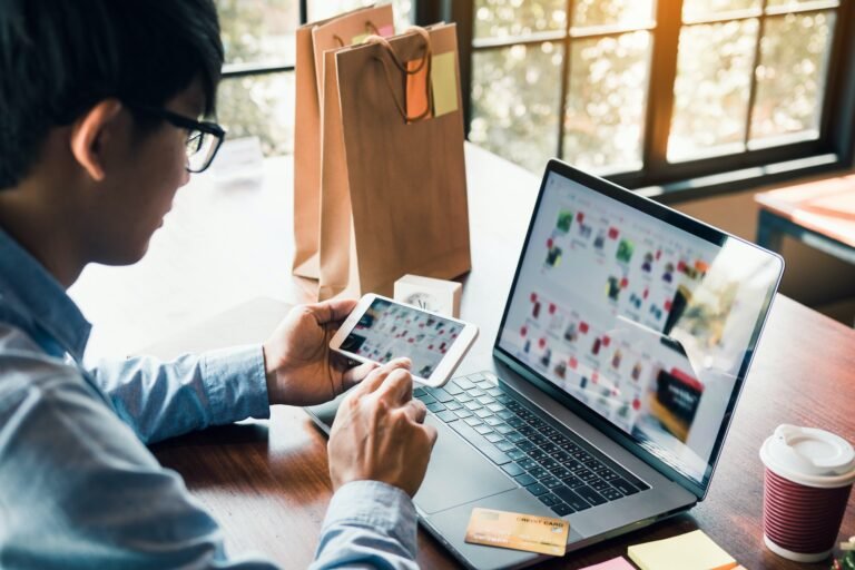 Hands of man are holding smart phones and using laptops computers are entering websites