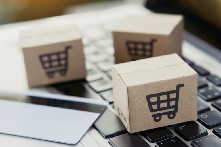 Shopping online. Credit card and cardboard box with a shopping cart logo on laptop keyboard.
